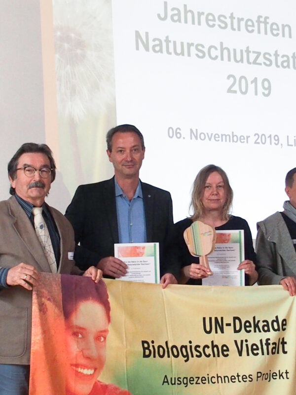 Verleihung der Auszeichnung "UN- Dekade Biologische Vielfalt". Alle Beteiligten stehen hinter einem entsprechenden Banner