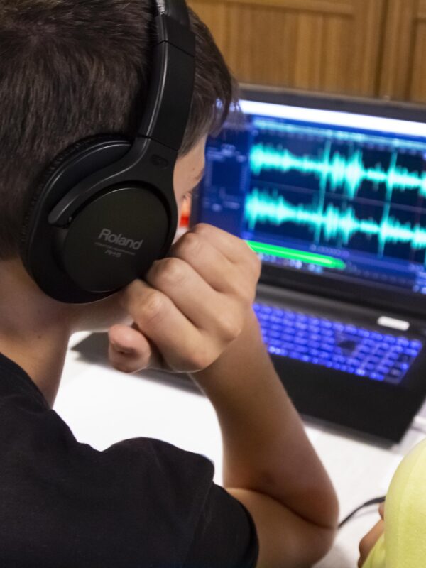 Junge Naturwächter mit aufgesetzten Kopfhörern vor einem Audioschnittprogramm