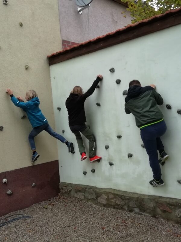 4 Kinder bouldern an der Kletterwand